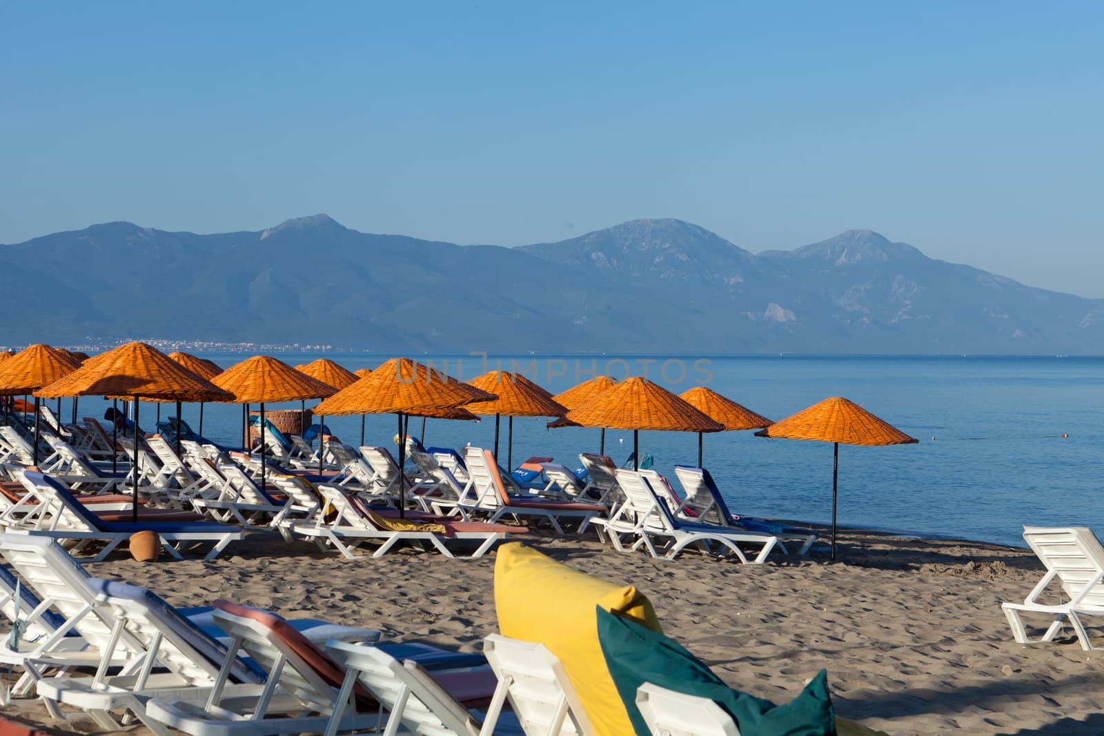 Beach loungers and umbrellas on the sea.
