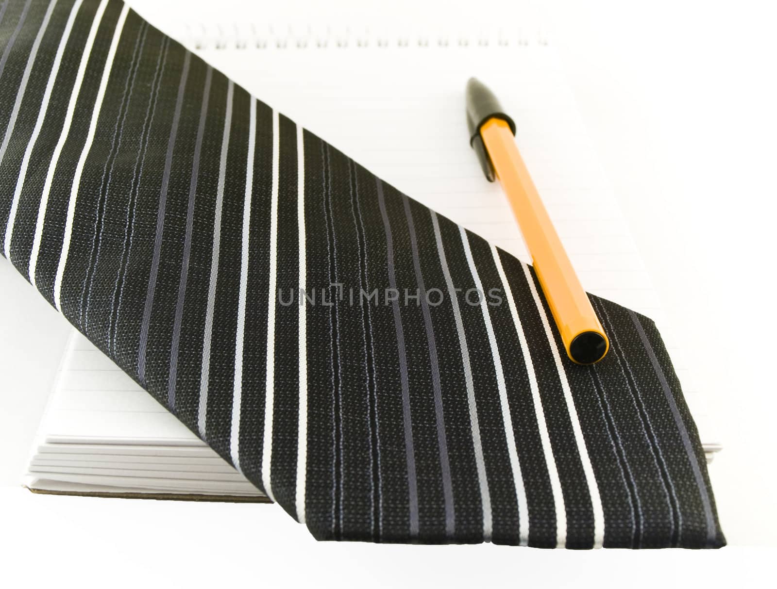 Ballpoint Pen and Tie on Notepad on White Background by bobbigmac