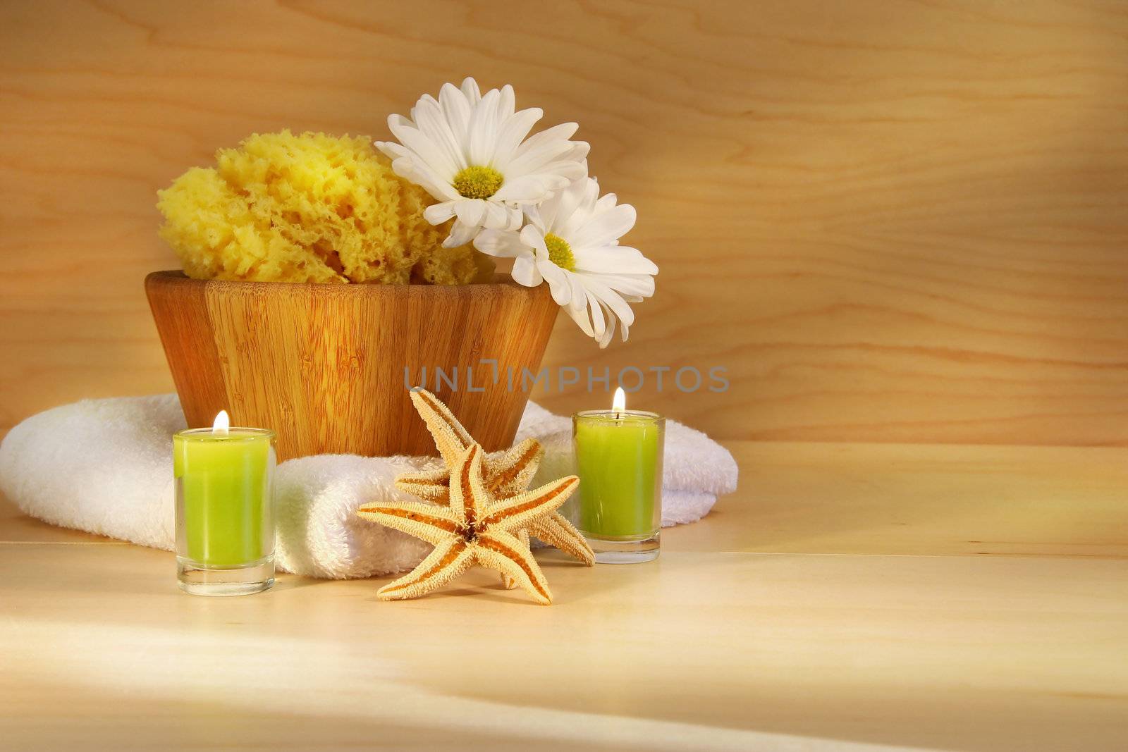 Wooden bowl, sponge, towel and candles on wooden counter