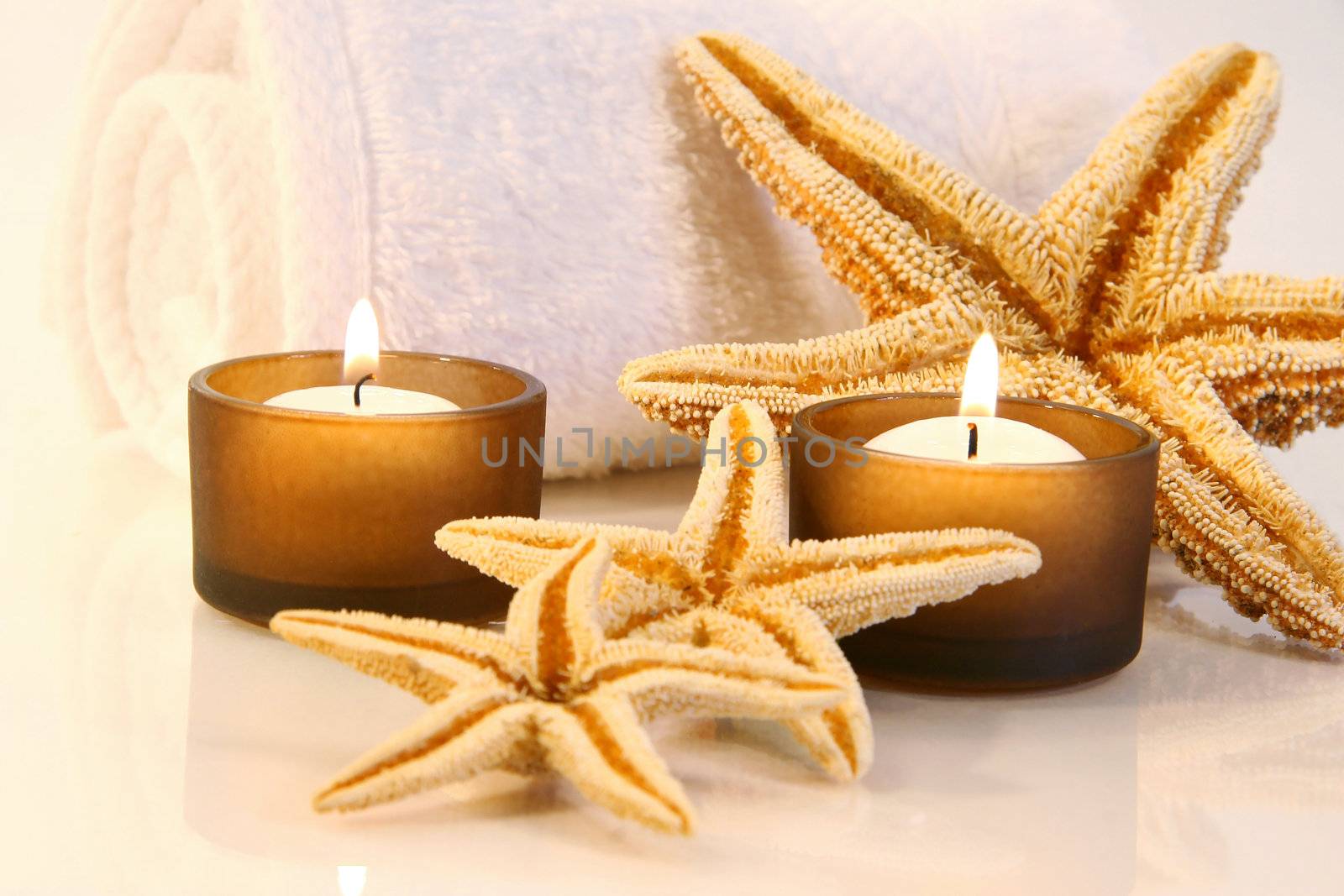 Little brown candles, towel and starfish with a warm glow