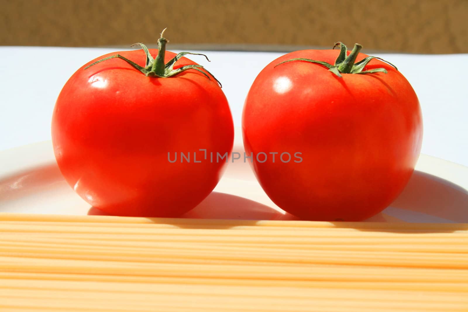 Close up of a pasta and tomatos on a plate.
