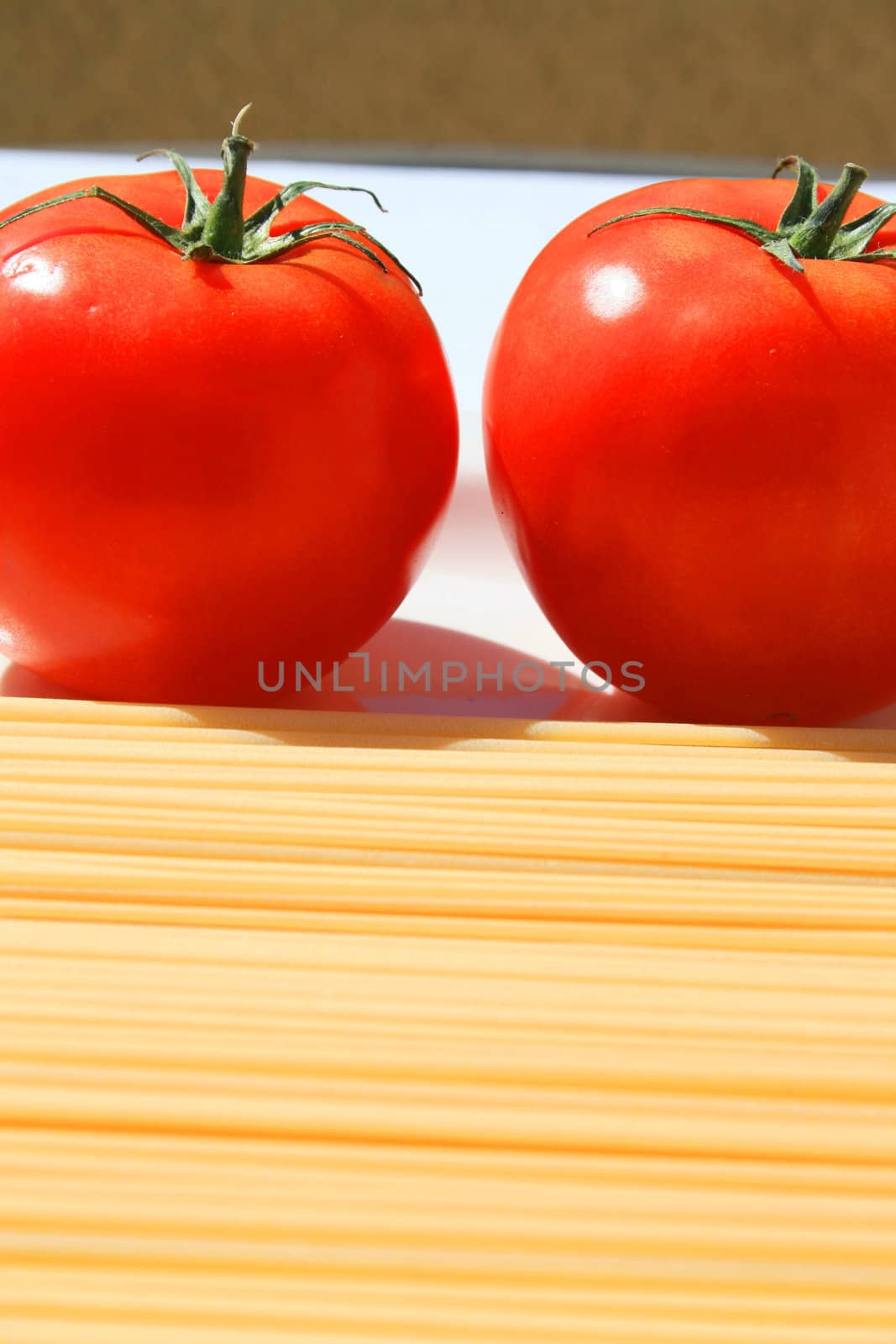 Close up of a pasta and tomatos on a plate.
