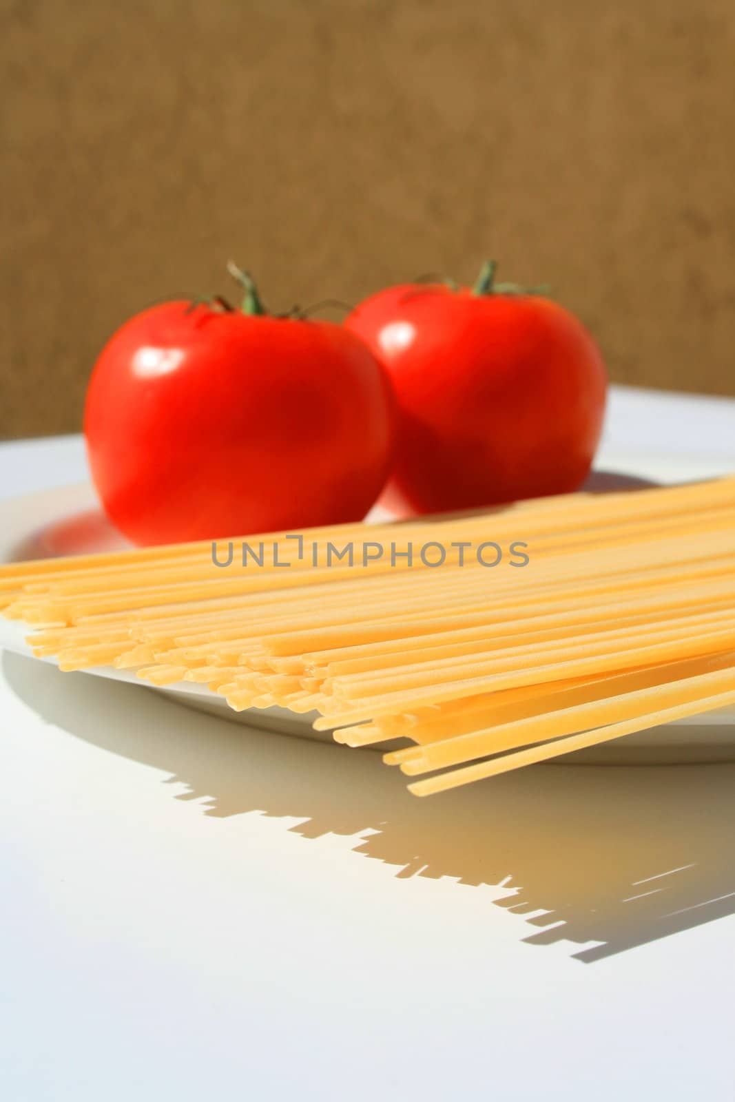 Close up of a pasta and tomatos on a plate.
