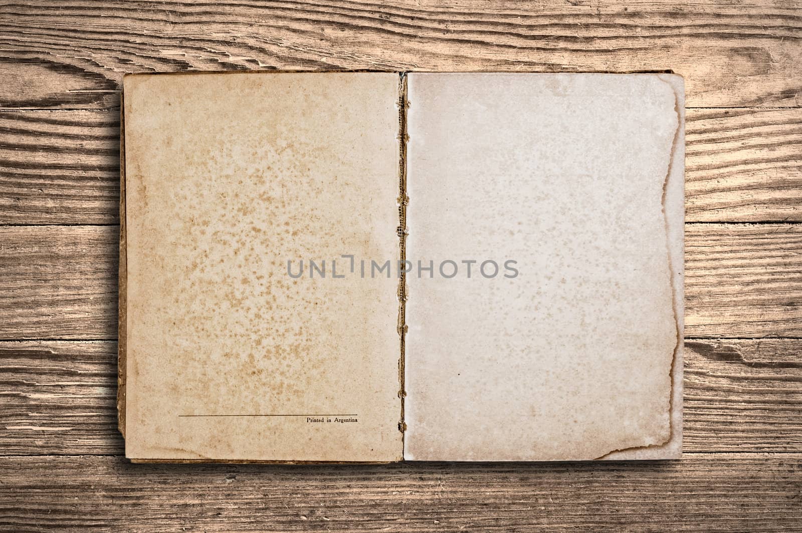 Vintage book with blank pages over an old wooden table.