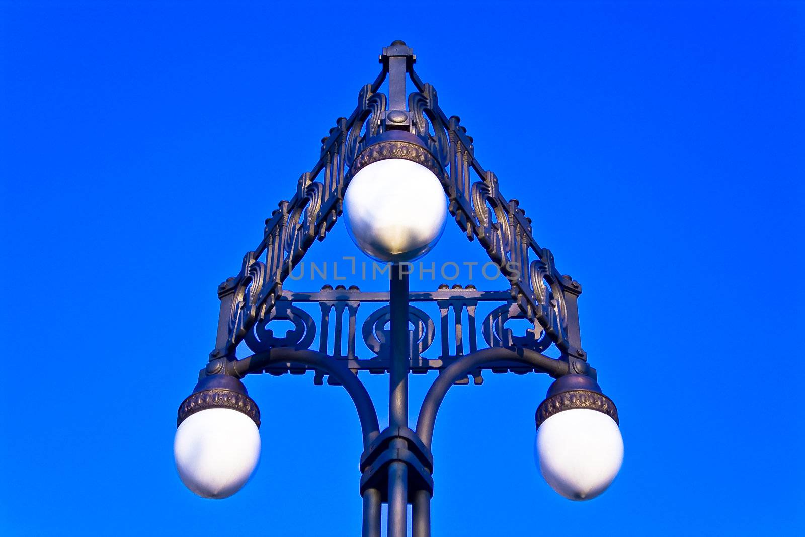 Old street lamppost on blue sky