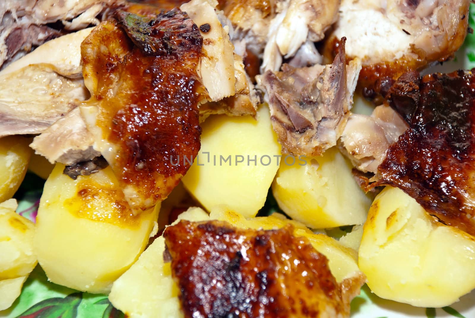 Tasty fried dish of chicken and potatoes, closeup.
