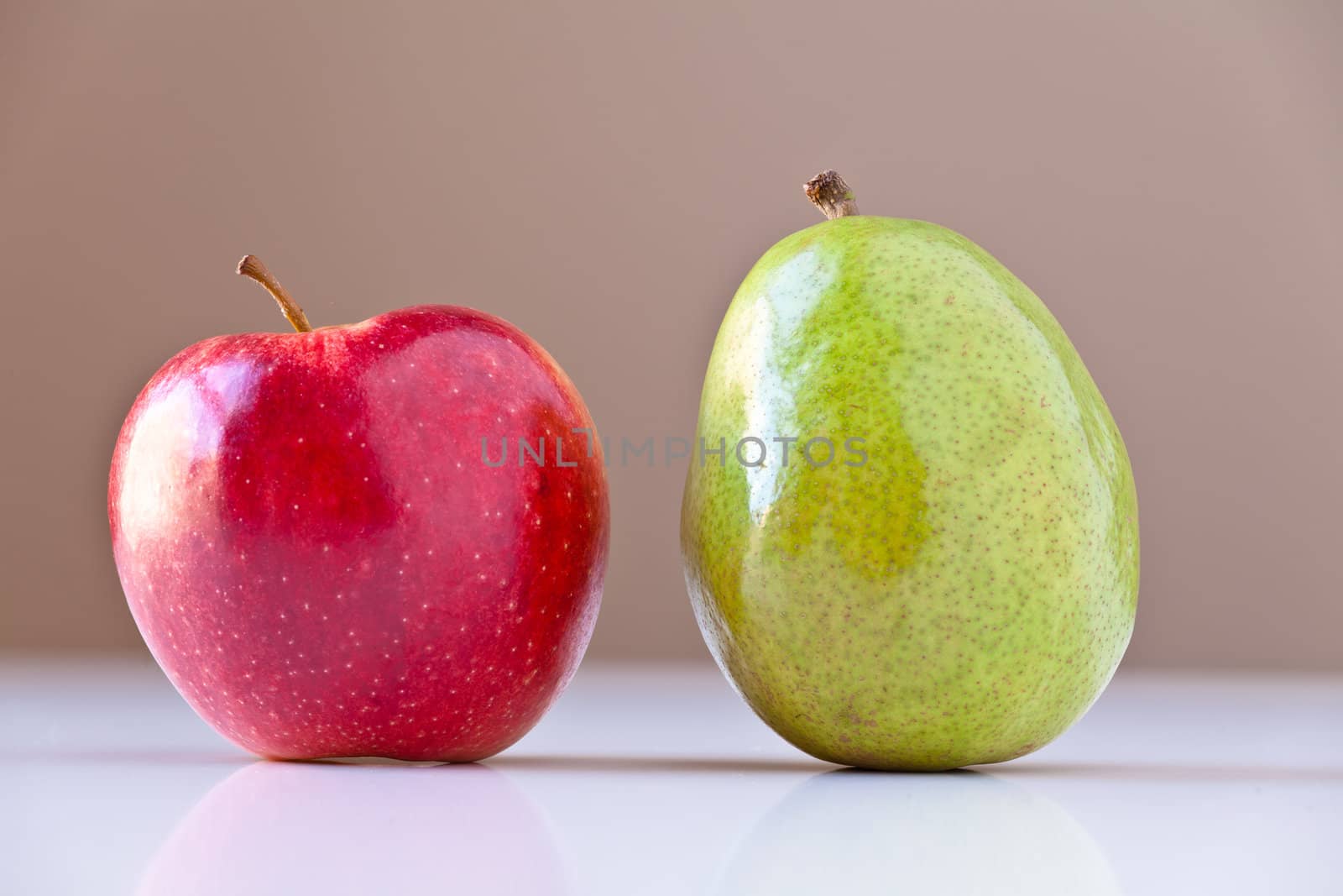 Two pieces of fruits on white with taupe brown background. Concepts: nutrition, good food choices, balanced diet, good for you