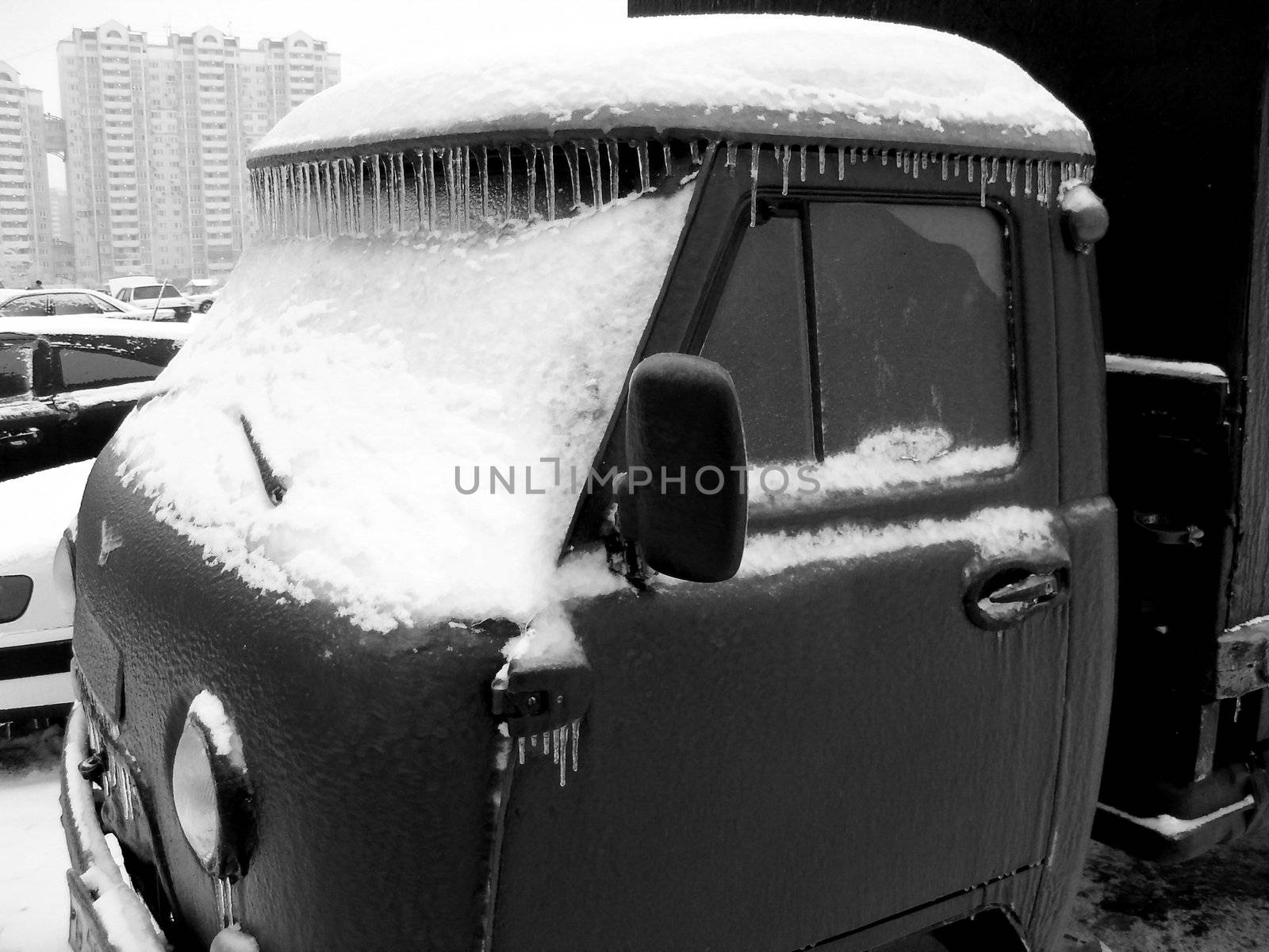 Car wholly in ice with icicles after winter storm