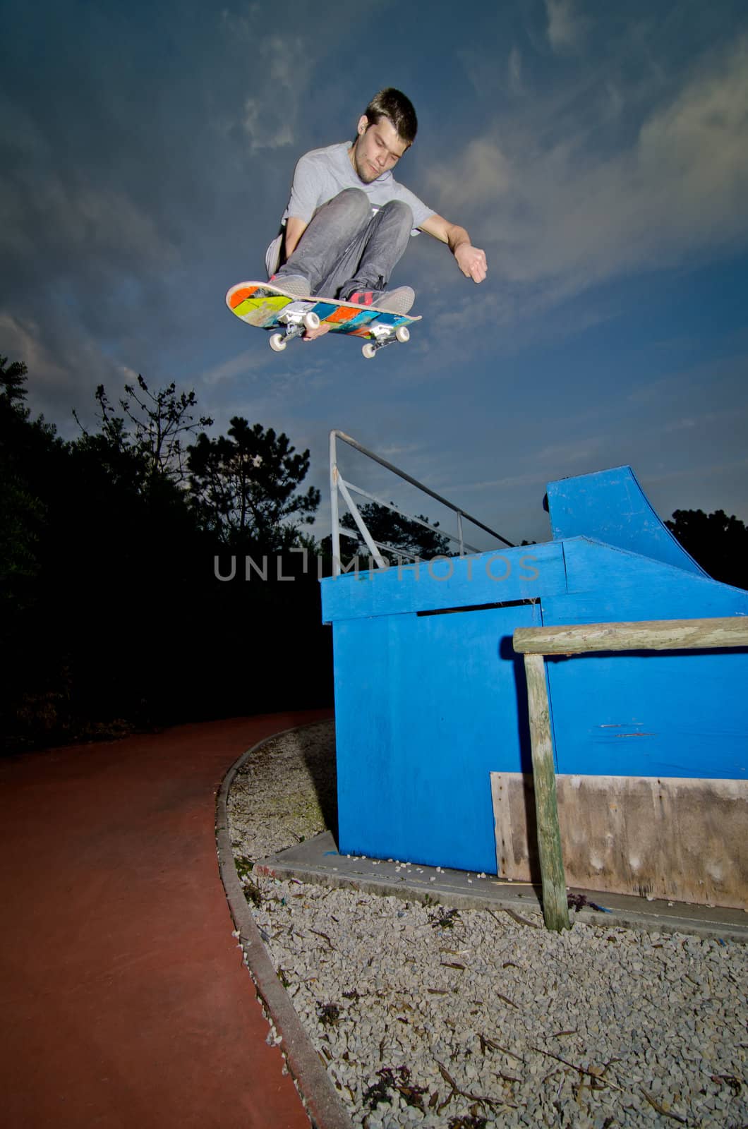 Skateboarder flying over a fap on sunset at the local skatepark.