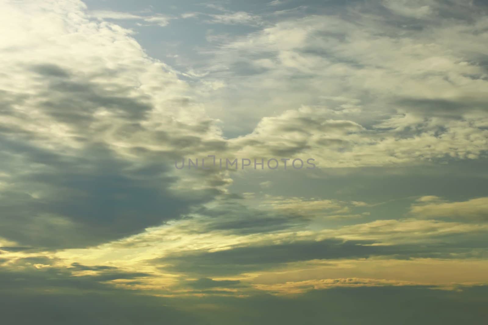 Dramatic cloudscape at sunset time. Sunlight passes through the dense clouds