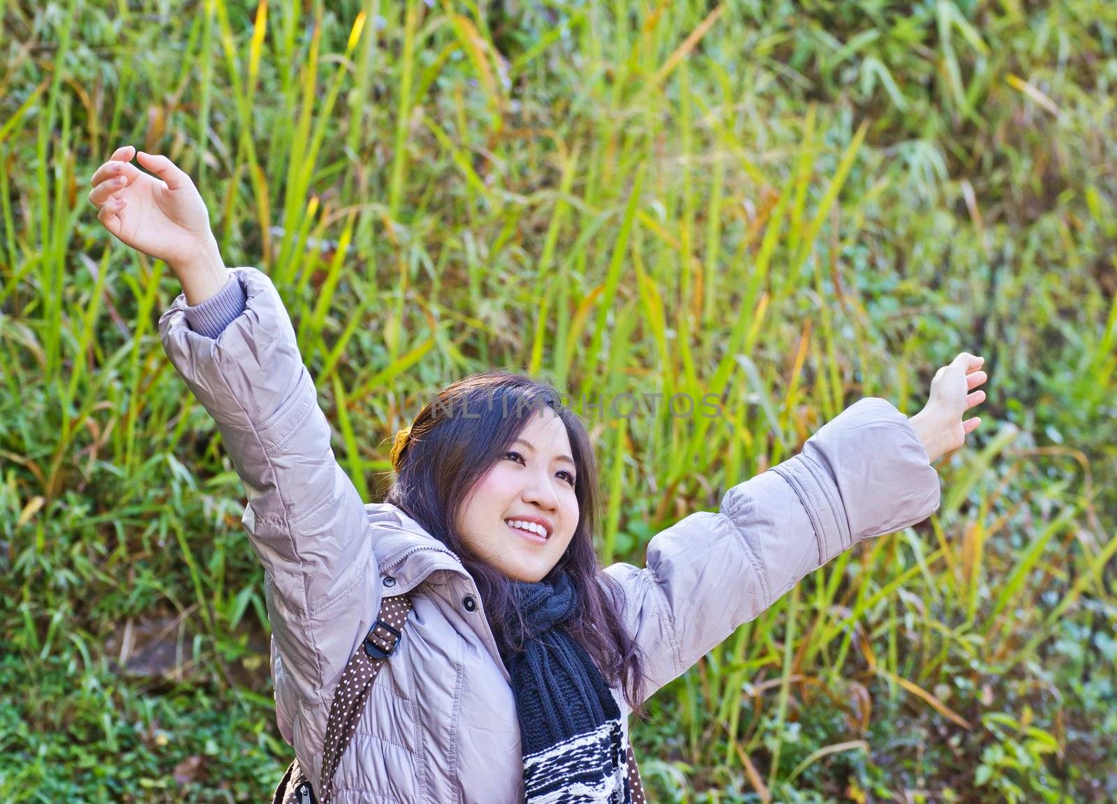 Happy young woman with hands up by Myimagine