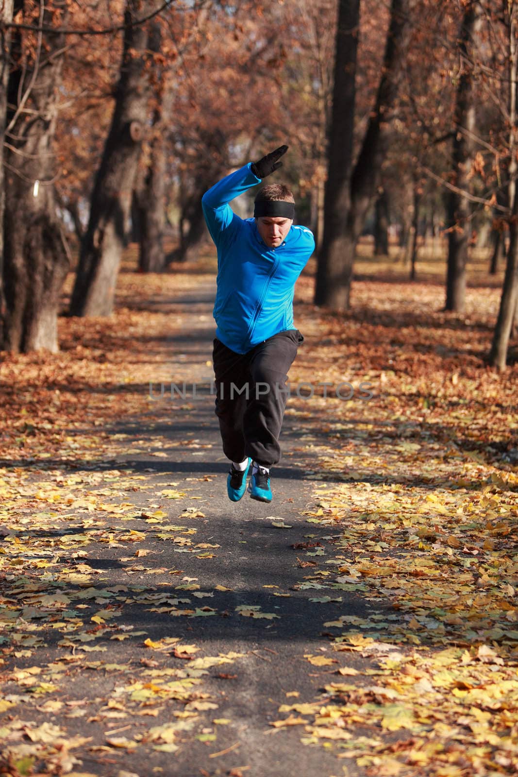 Young man doing fitness in a park in autumn.