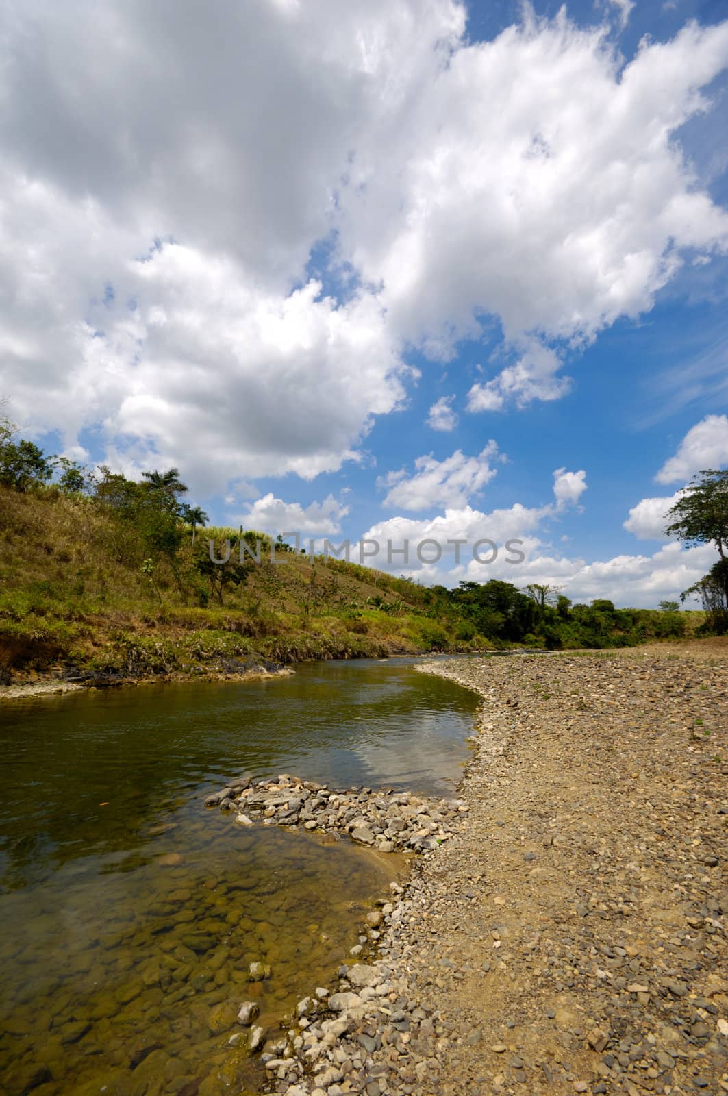 River and green nature with white clouds. Dominican Republic.