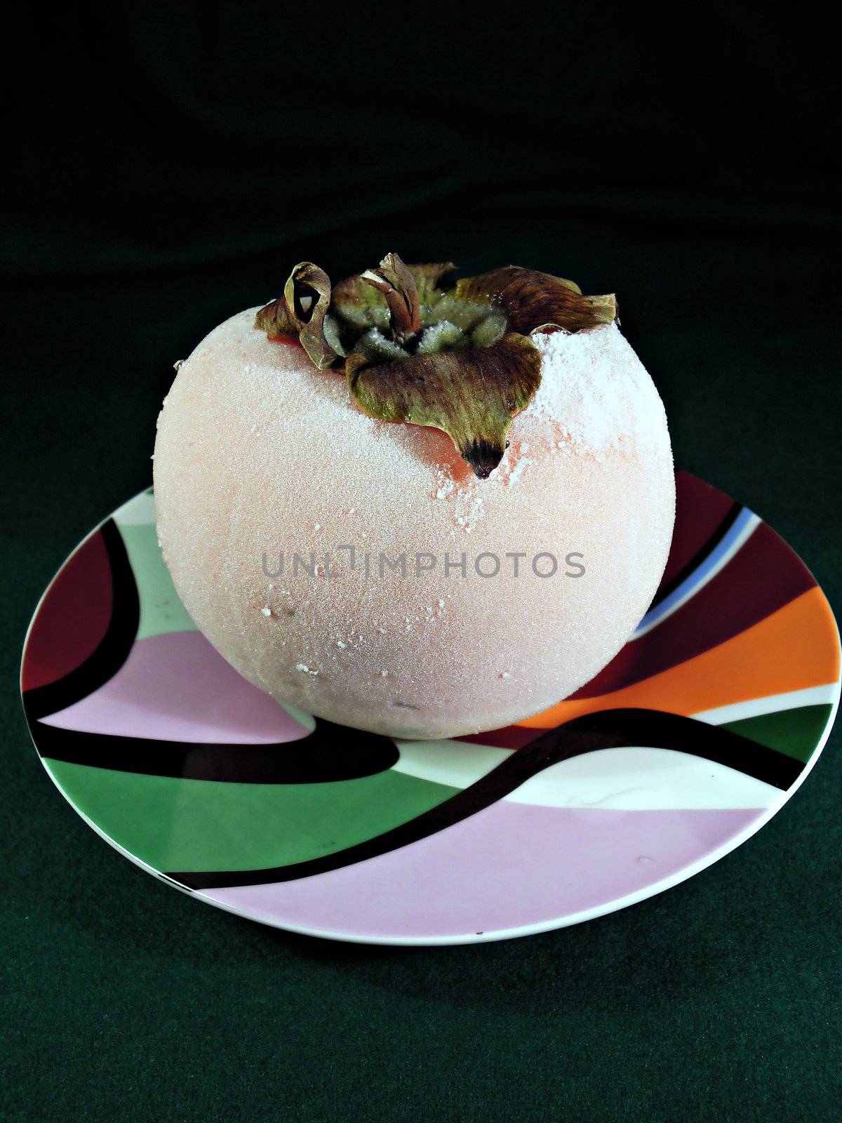 Frozen persimmon with white ice on plate