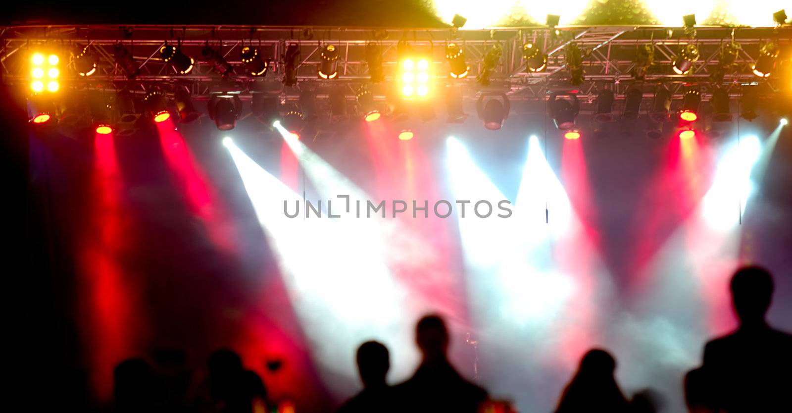 Crowd of people in front of spotlights at a concert.