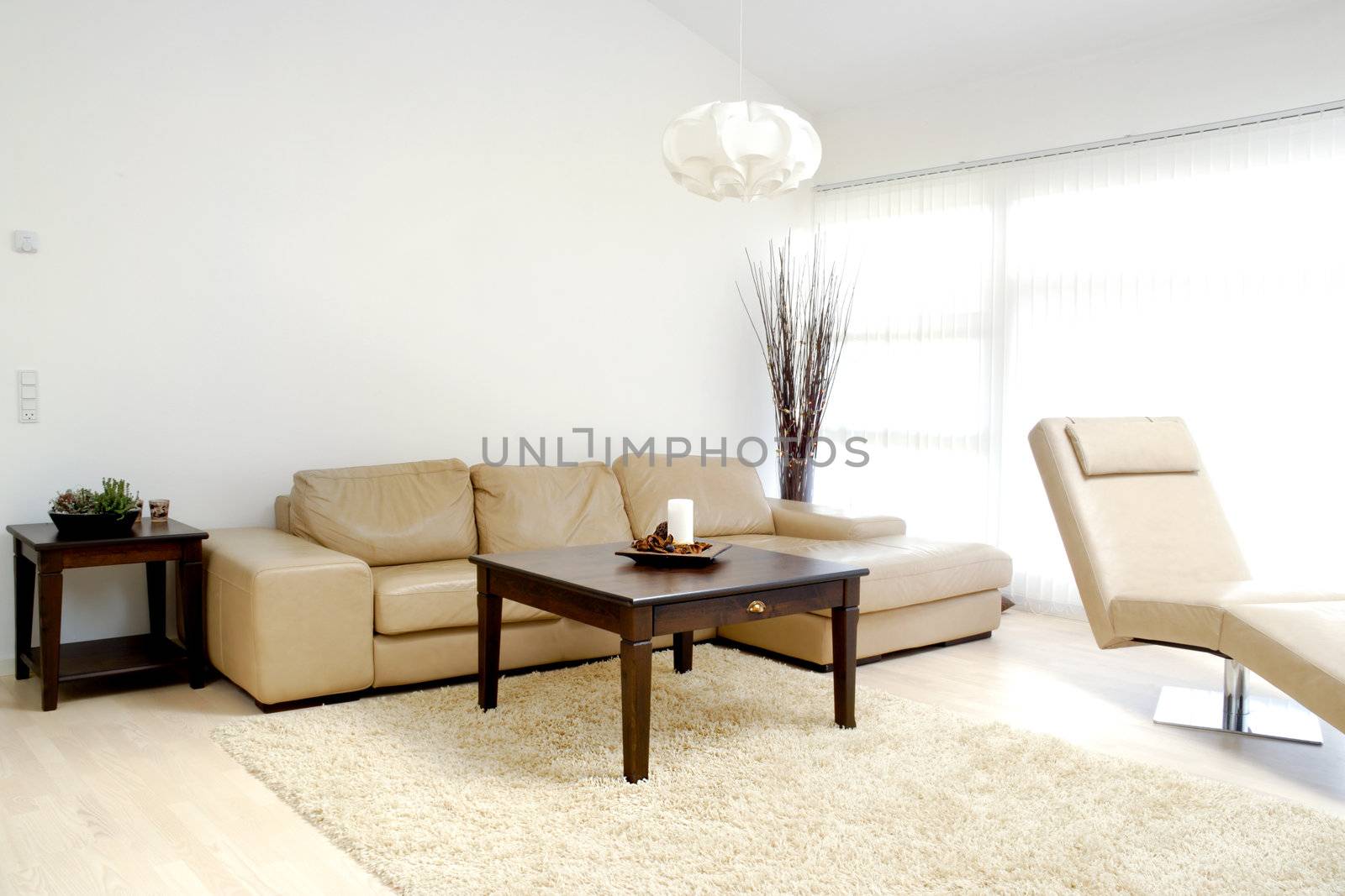 A modern living room with table, sofa and armchair.