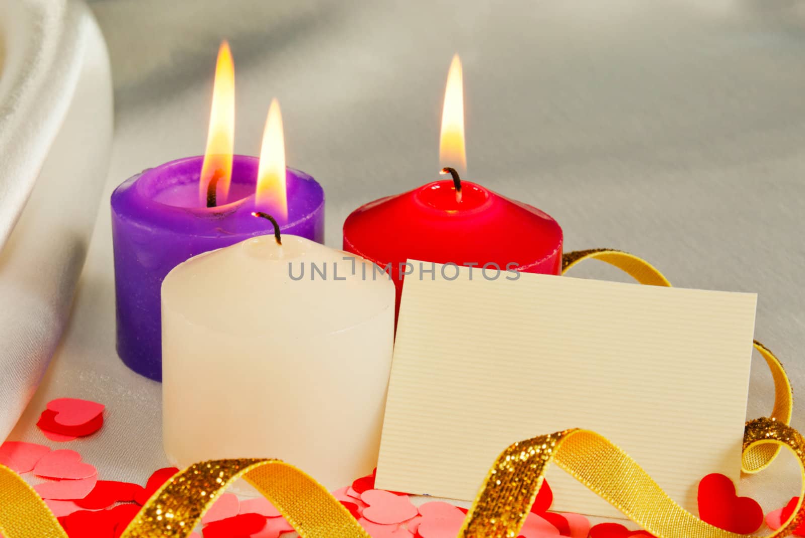 Three burning candles over light background