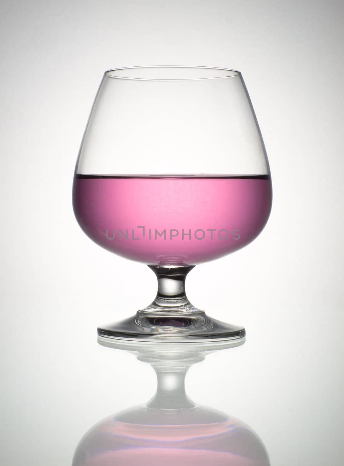 Pink wine in brandy glass and reflection by nuttakit