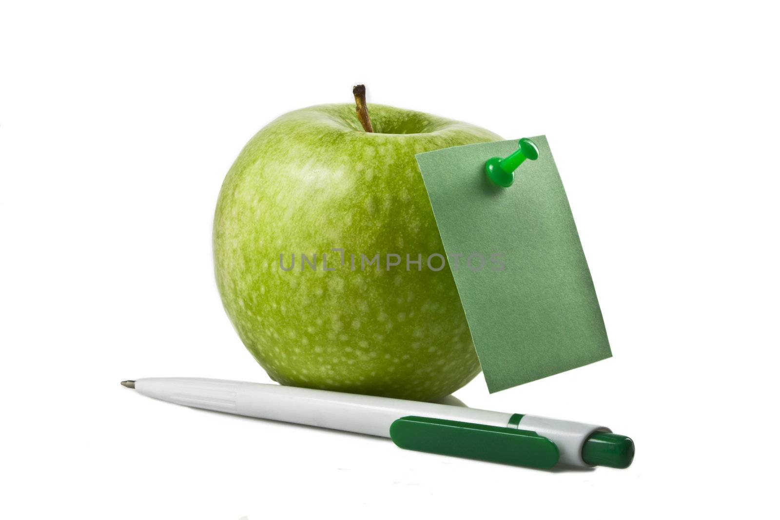 Photo of an apple with a sticker and a pen