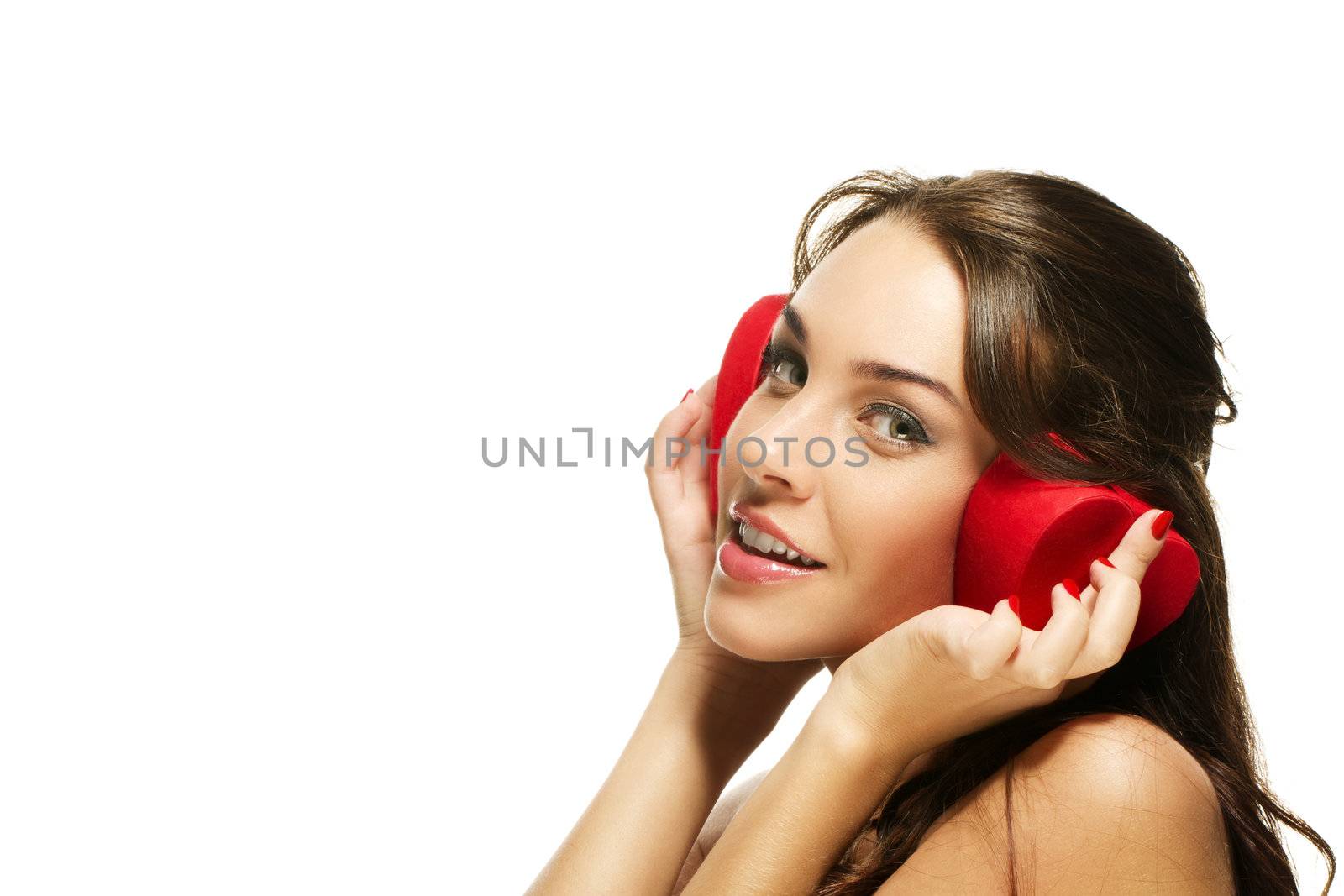 beautiful happy woman holding red heart shaped box on her ears on white background