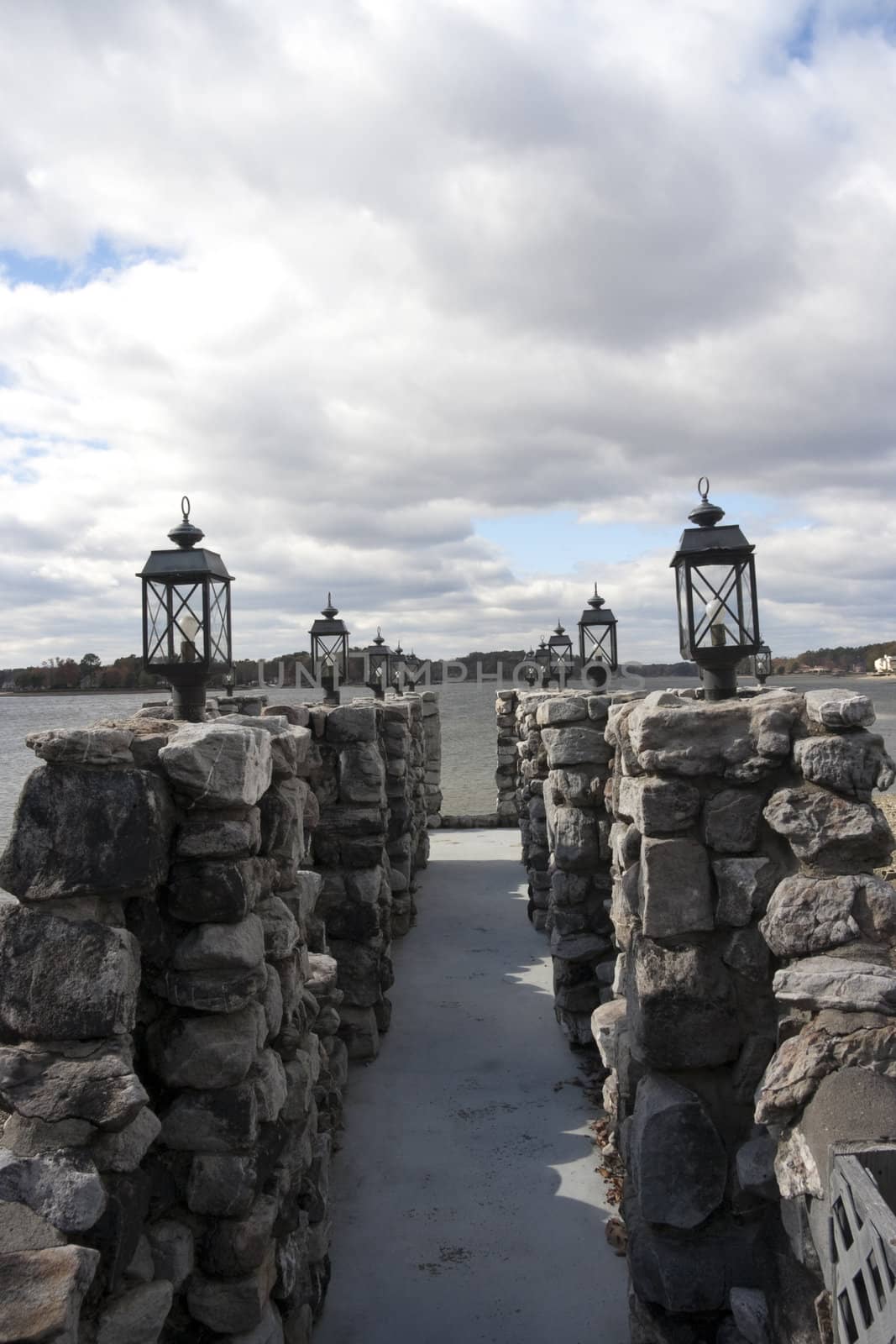 A pier made out of stone and with black lights on the edge.