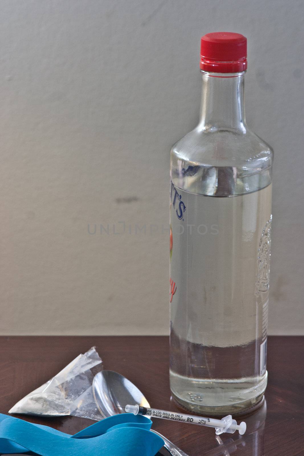 White powder drug with syringe and liquor bottle