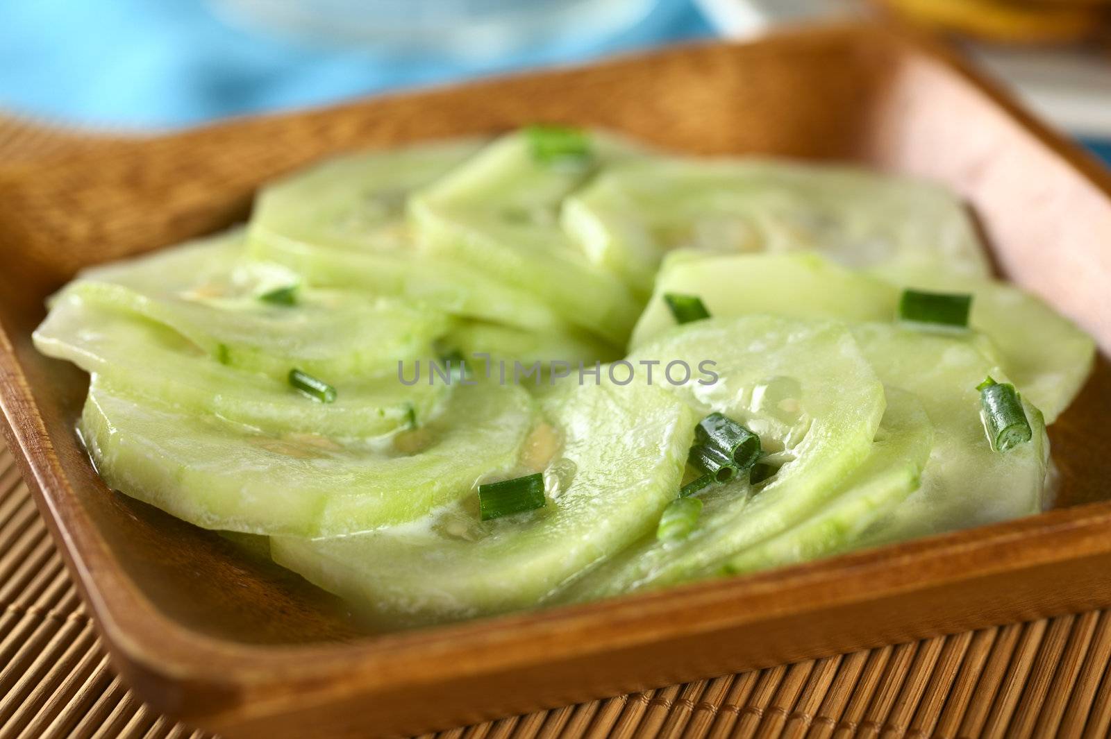 Fresh cucumber salad with chives and a yogurt dressing (Selective Focus, Focus on the chives in the front)  