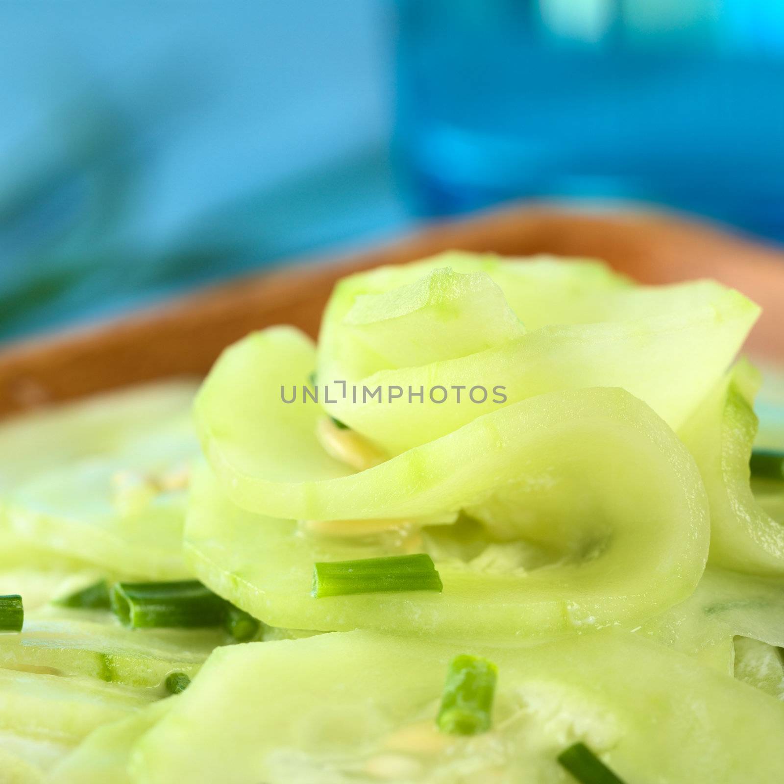 Fresh cucumber salad with chives and a yogurt dressing (Selective Focus, Focus in the middle of the picture)  