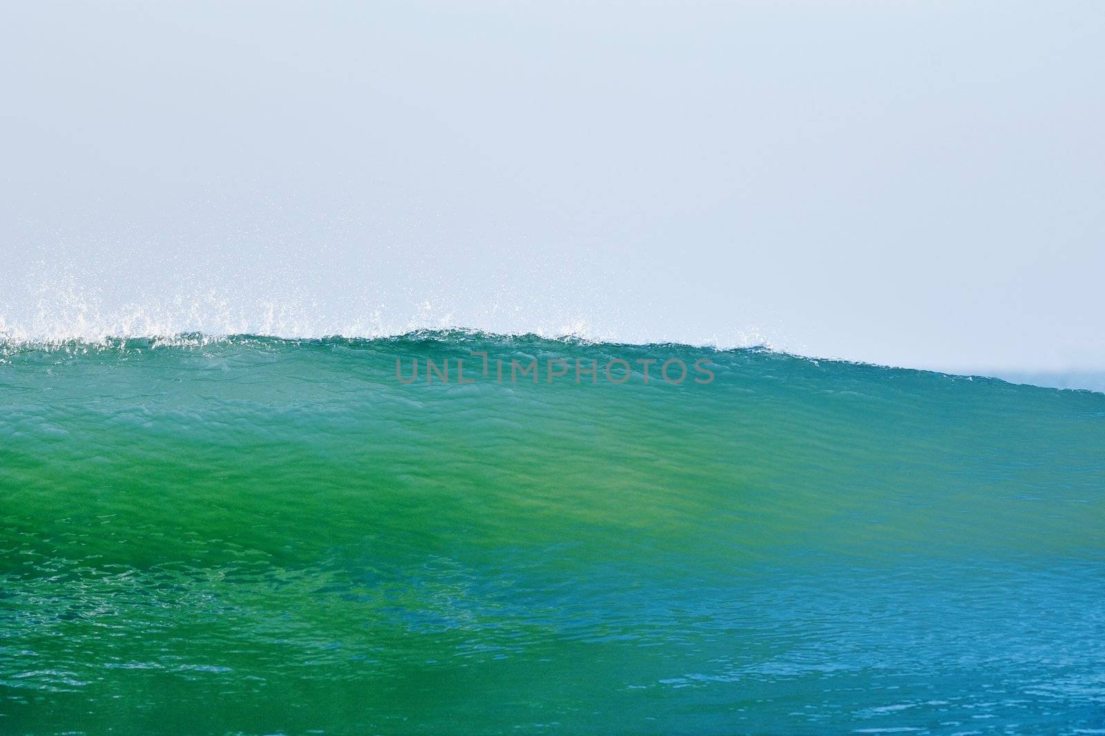 High blue-green sea wave on the background sky