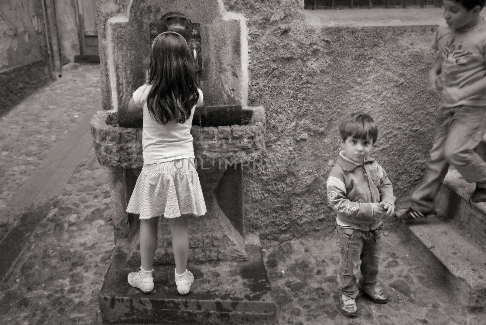 ACTIVE CHILDREN IN ALLEY, LONGOBUCCO, ITALY, SEPTEMBER 15 - 2011:  Kids in a narrow alley in the mountain village Longobucco, Calabria - Italy. Monochrome image - soft focus.