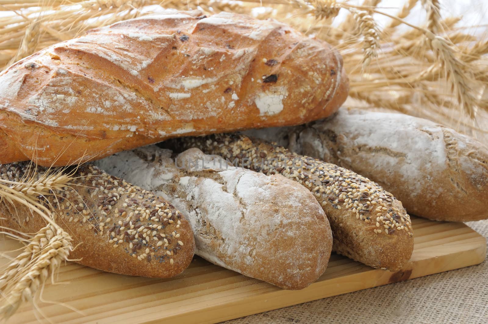 Varied with ears of wheat bread on a wooden board