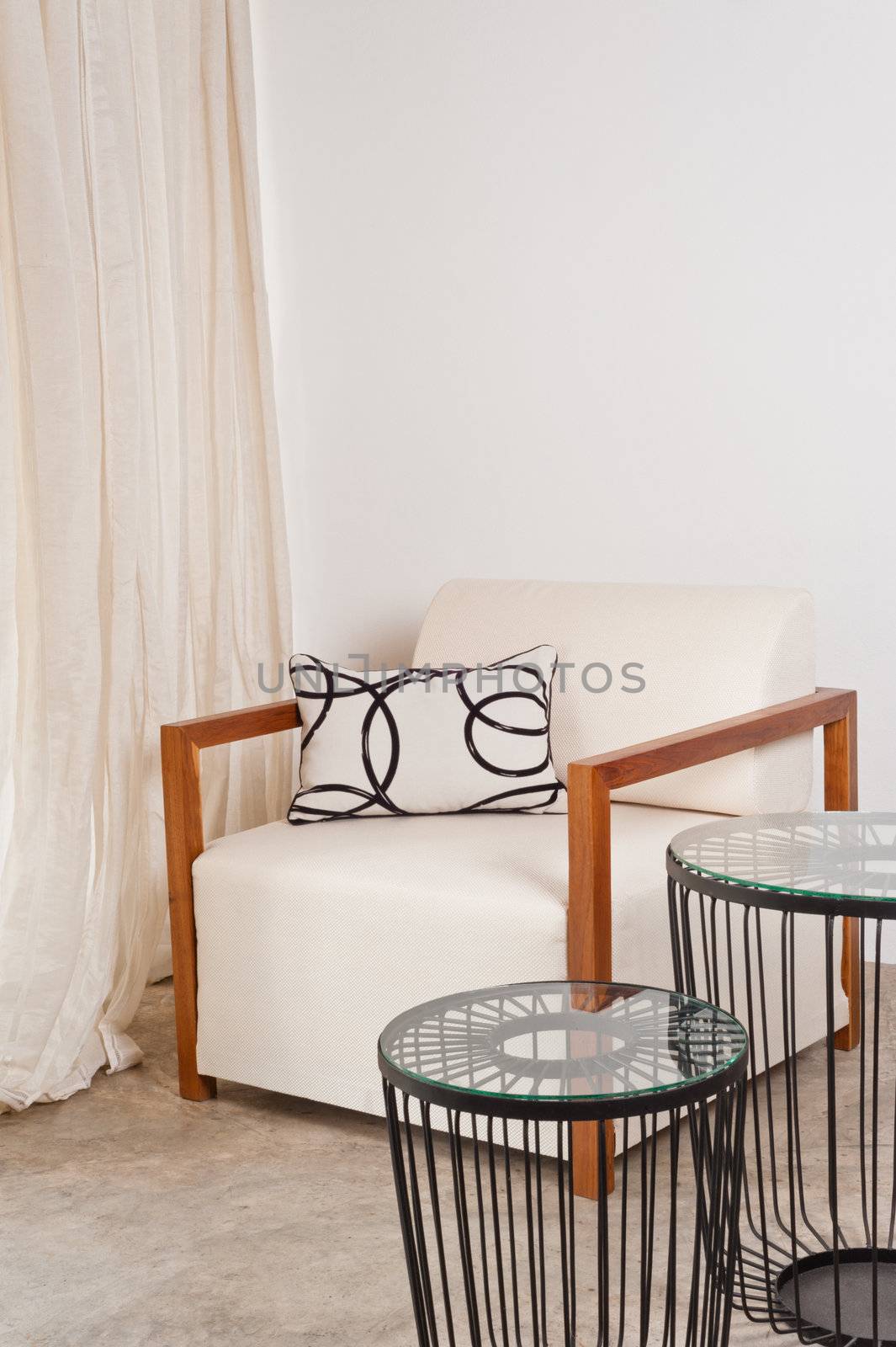 Bright white armchair in a living room with metal table 