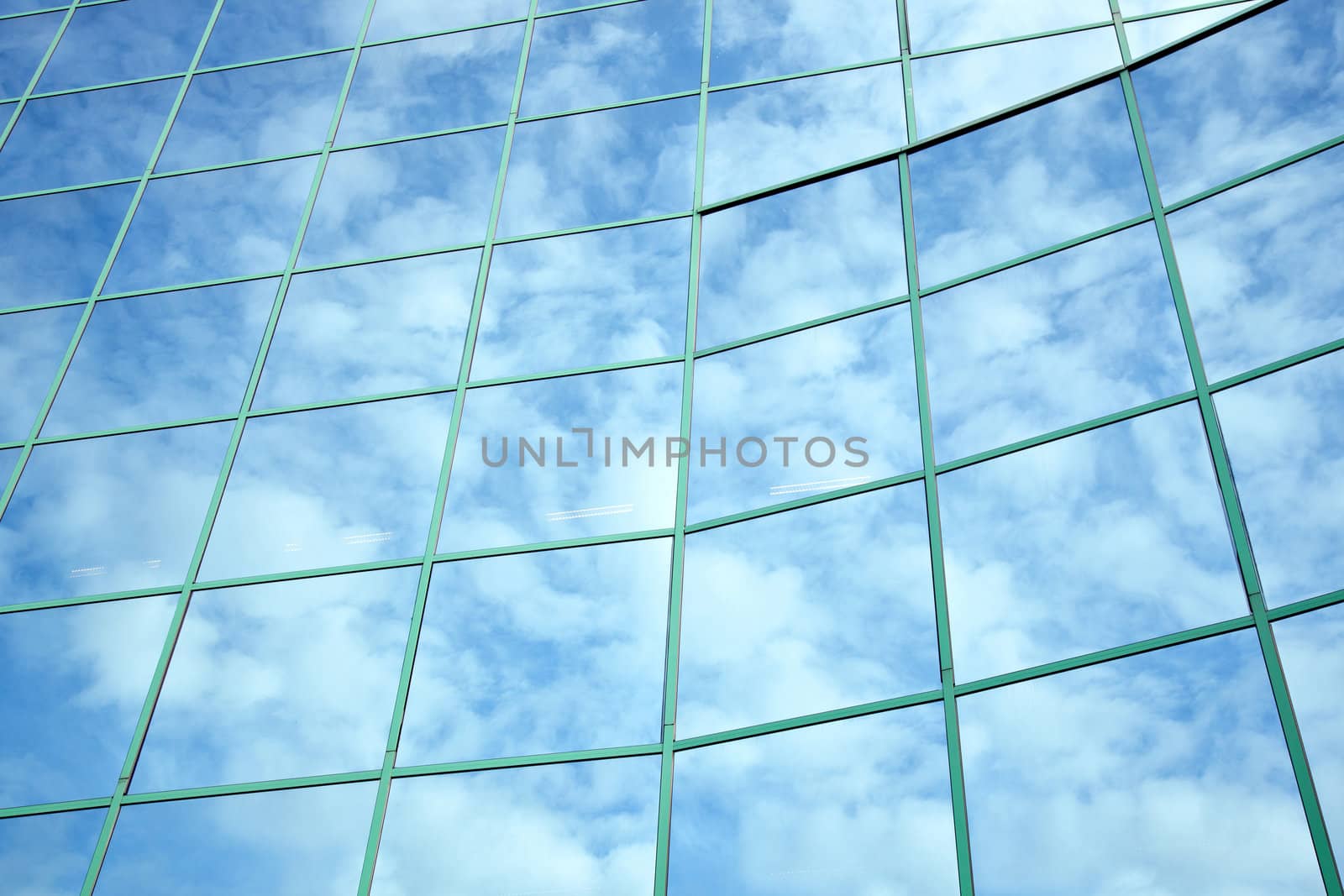 reflections of blue sky and clouds in curved facade by ahavelaar