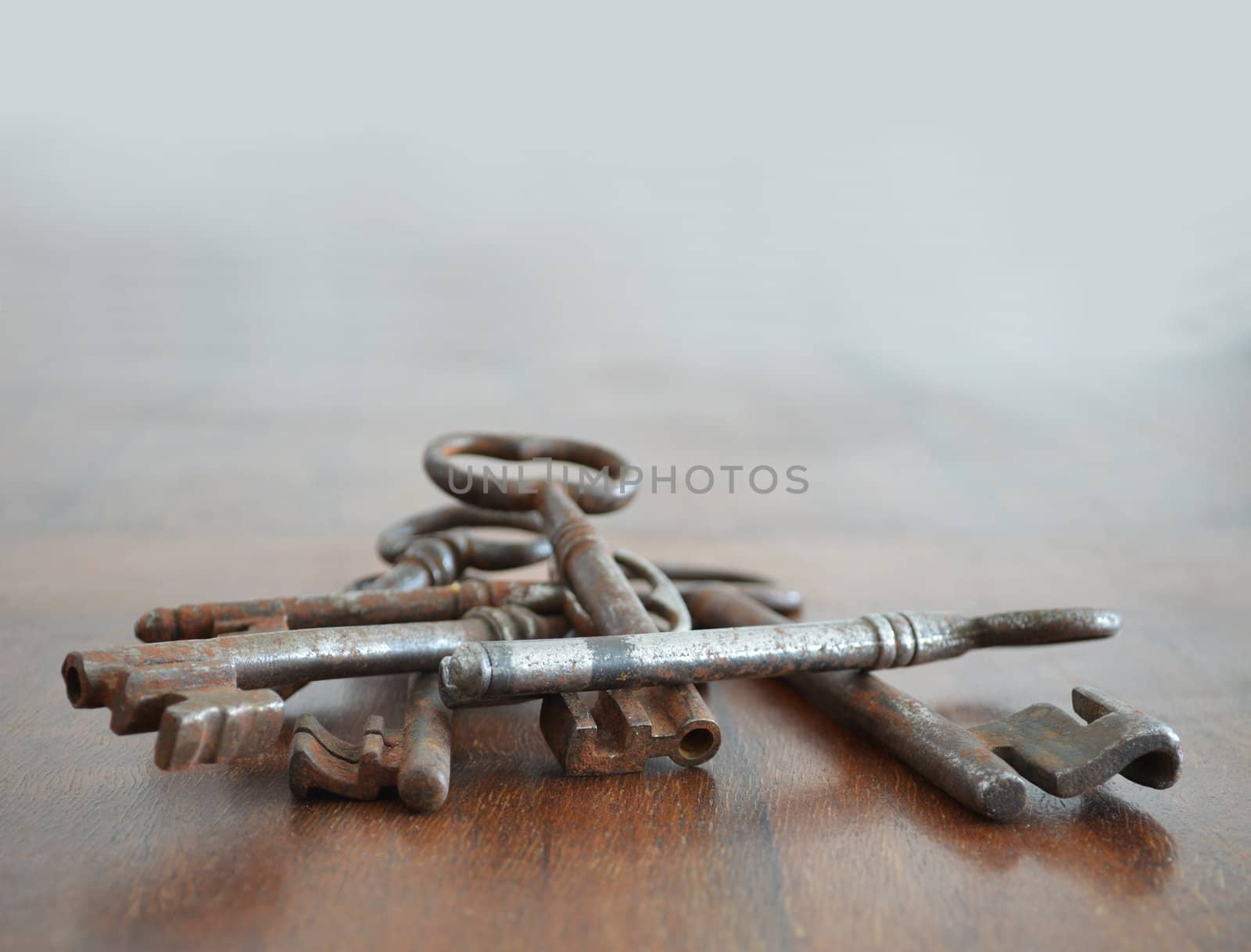 Bunch of old rusted keys on wood surface