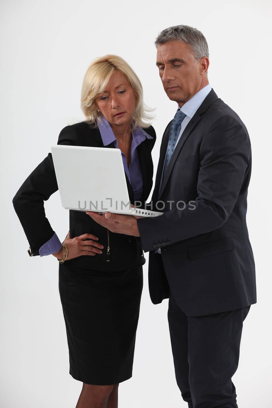 businessman and businesswoman looking at a laptop