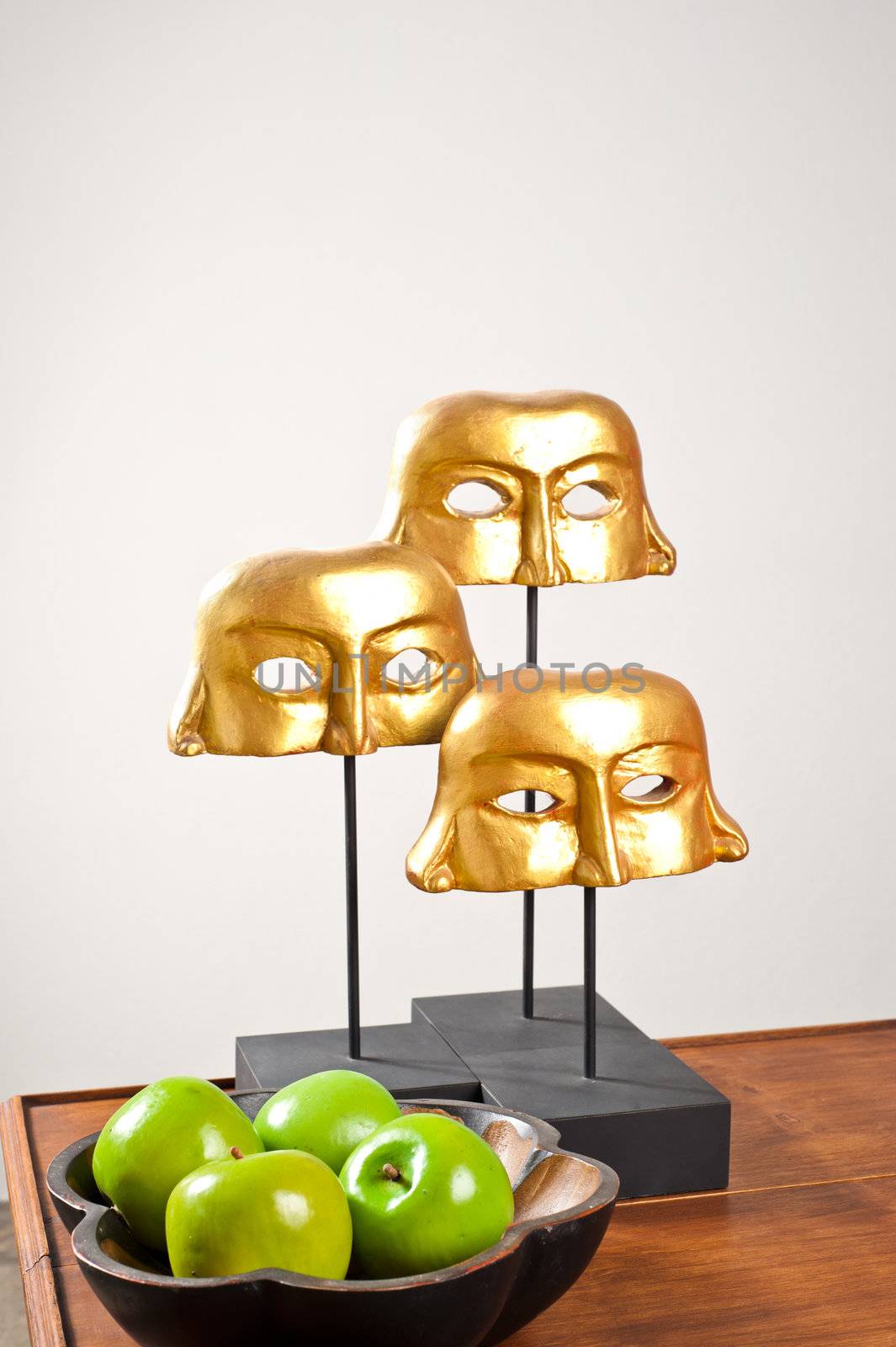 Golden masks as interior decoration on wooden table