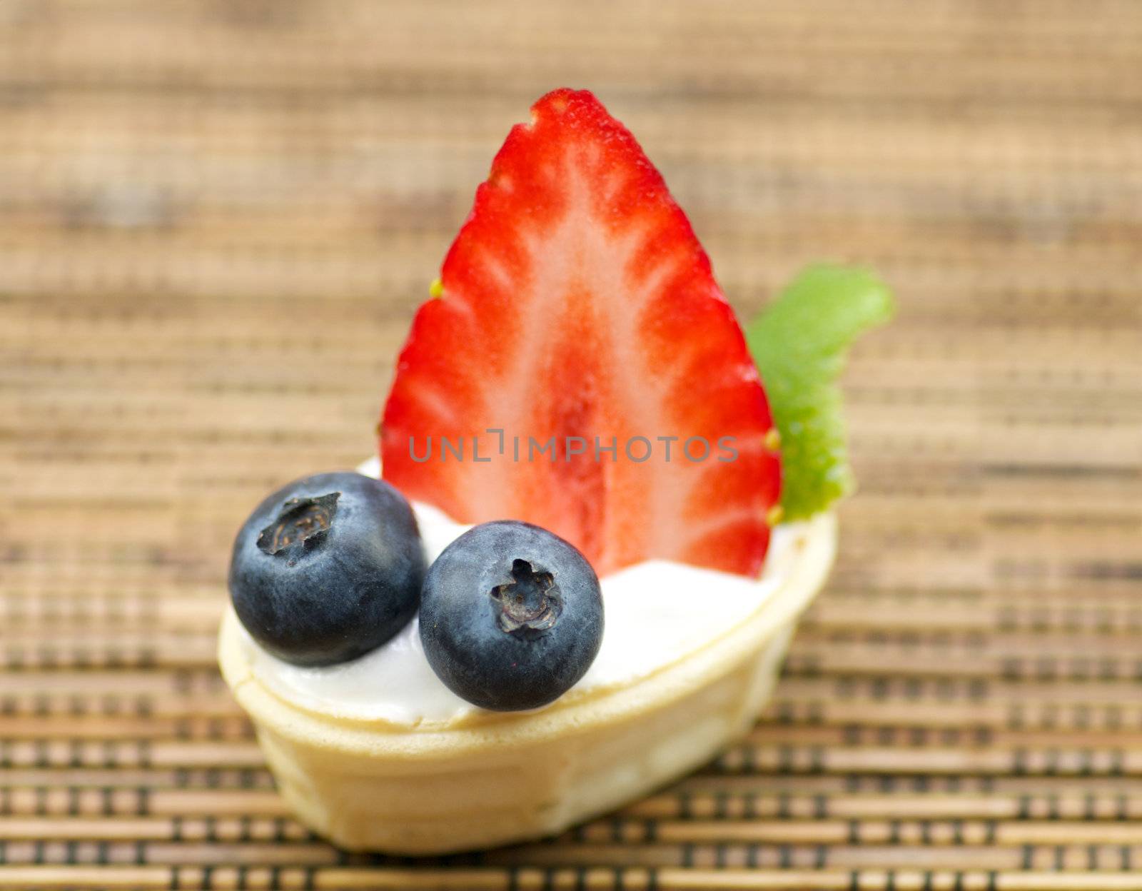 Tubules from shortcake dough with whipped cream, a strawberry and a blueberry