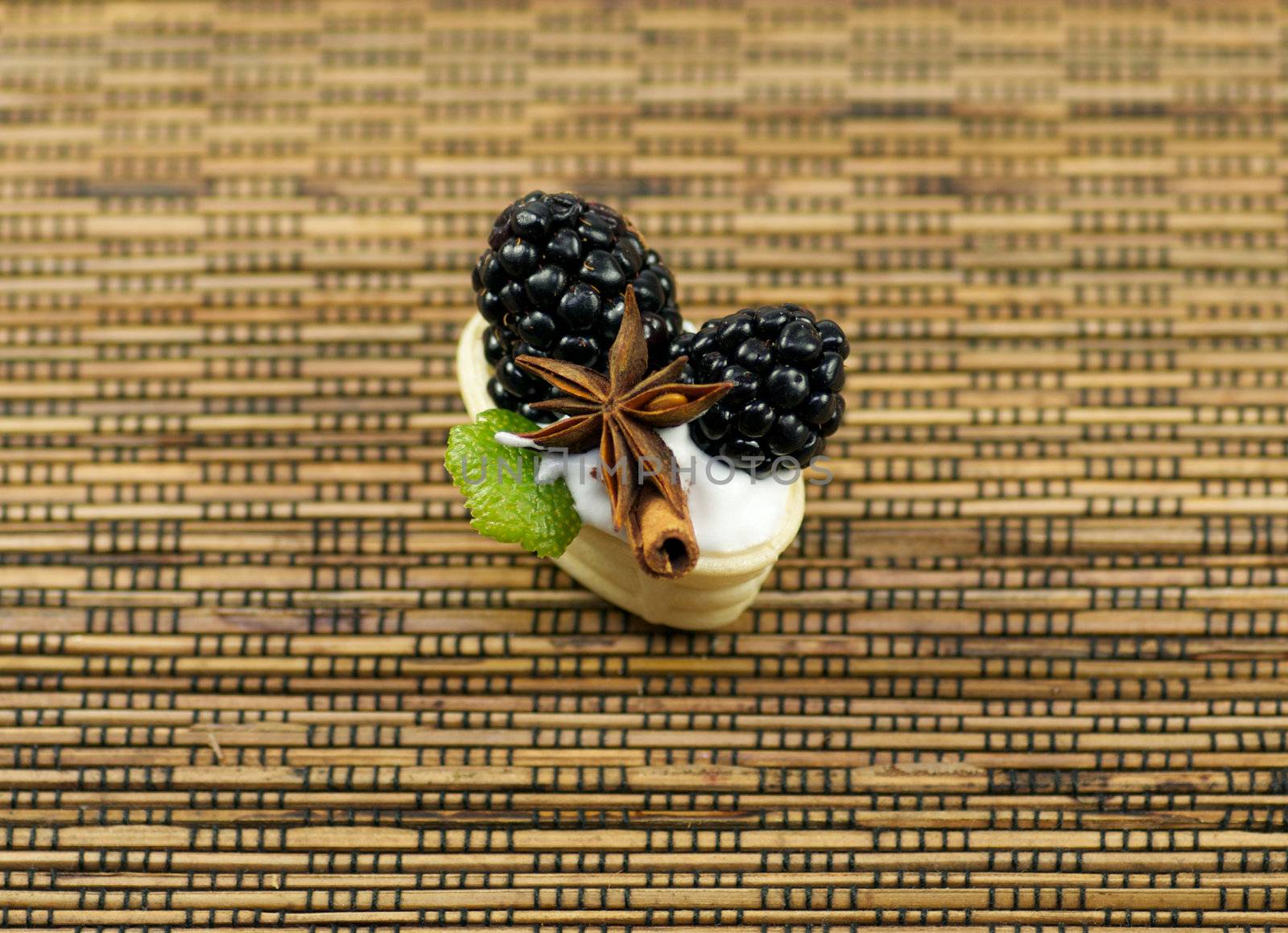 Small baskets from shortcake dough with whipped cream, a blackberry, cinnamon and anise by zhekos