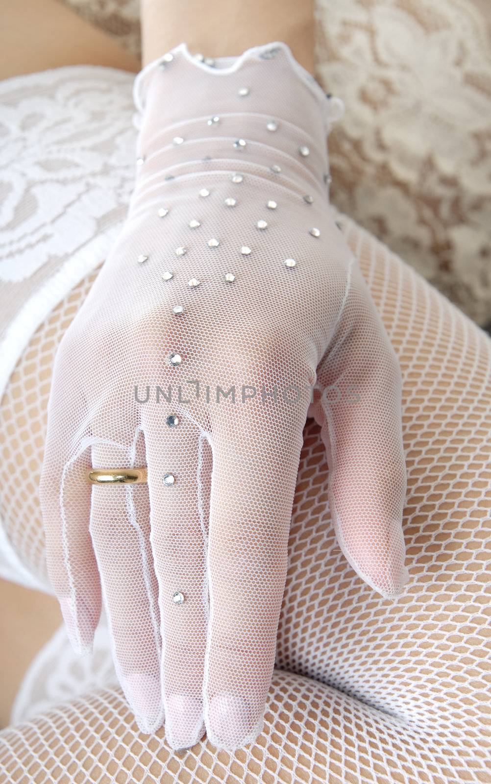 Close-up photo of the elegant hand in glove with wedding ring