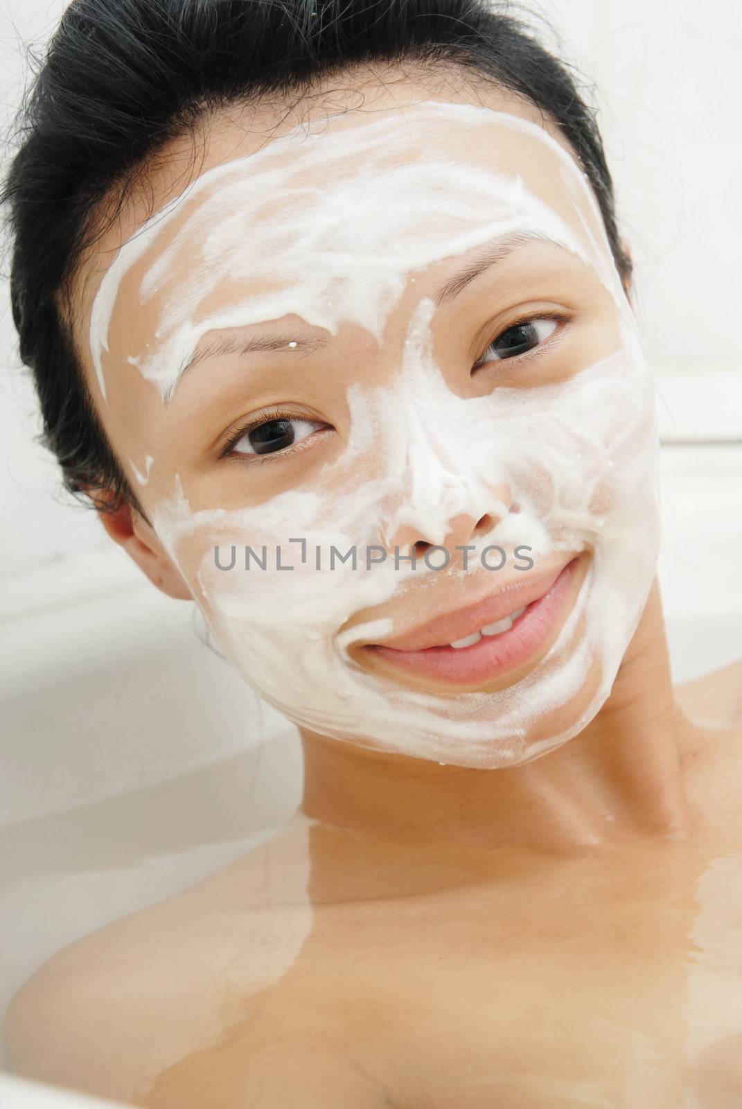 Closeup portrait of the woman in the bath with beauty mask