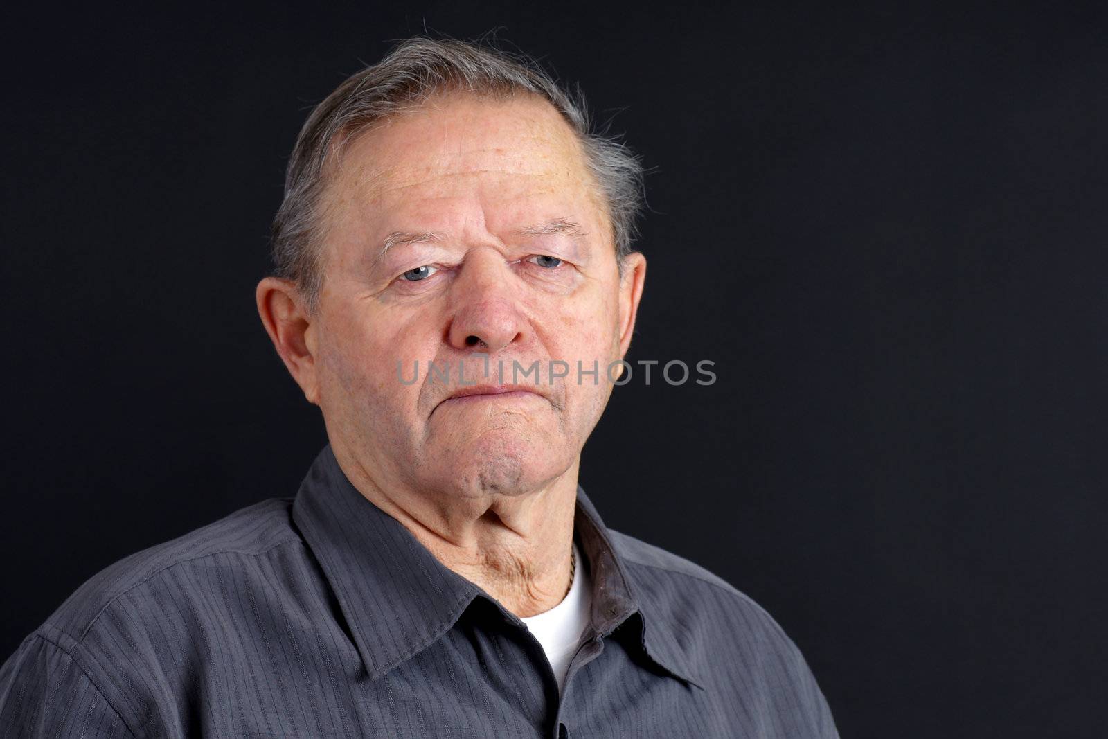 Portrait of sad or depressed senior man looking down over dark background, great details.