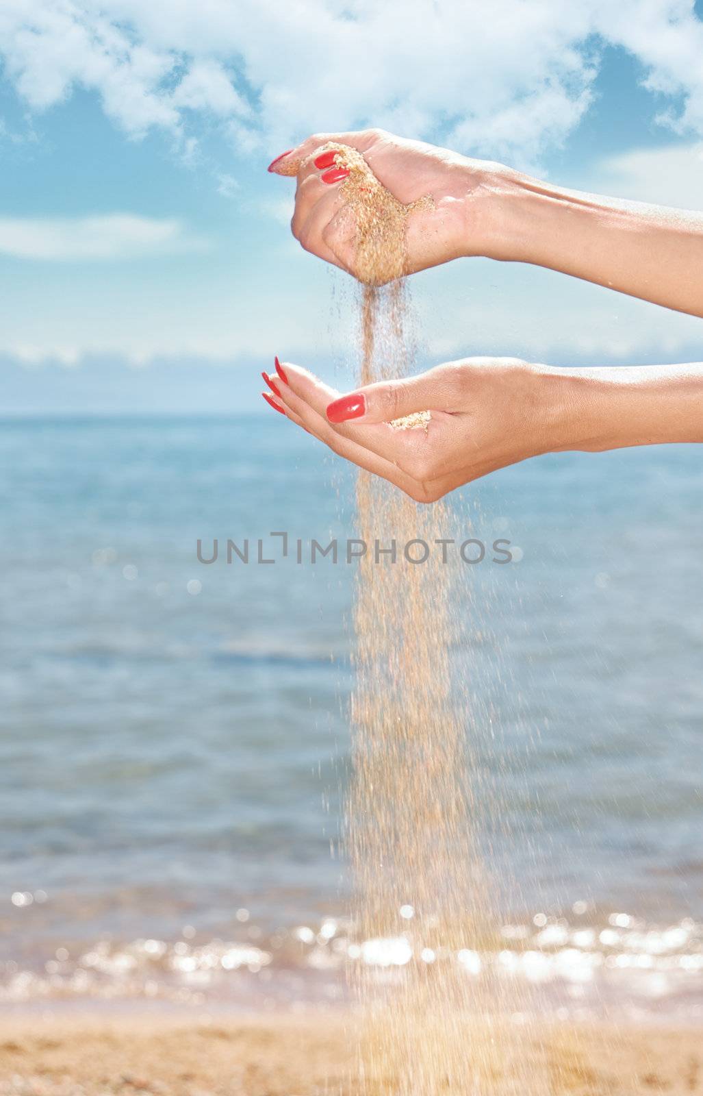 Close-up photo of the woman hands playing with sand