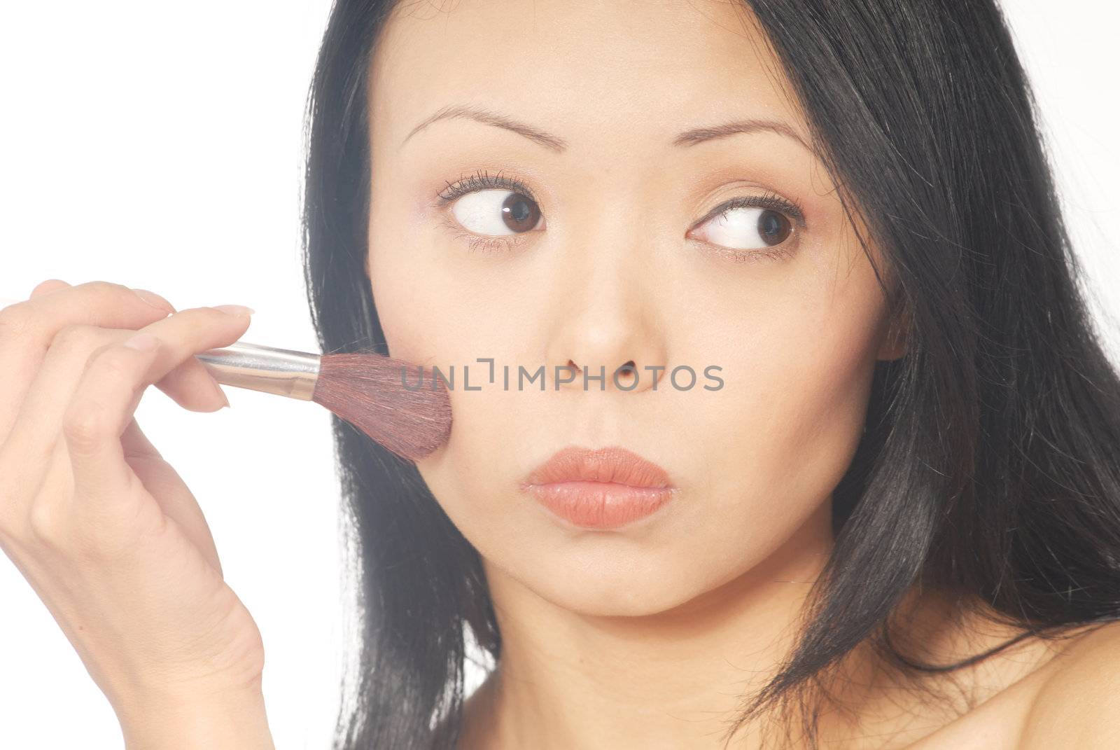 Close-up portrait of the young woman with makeup brush