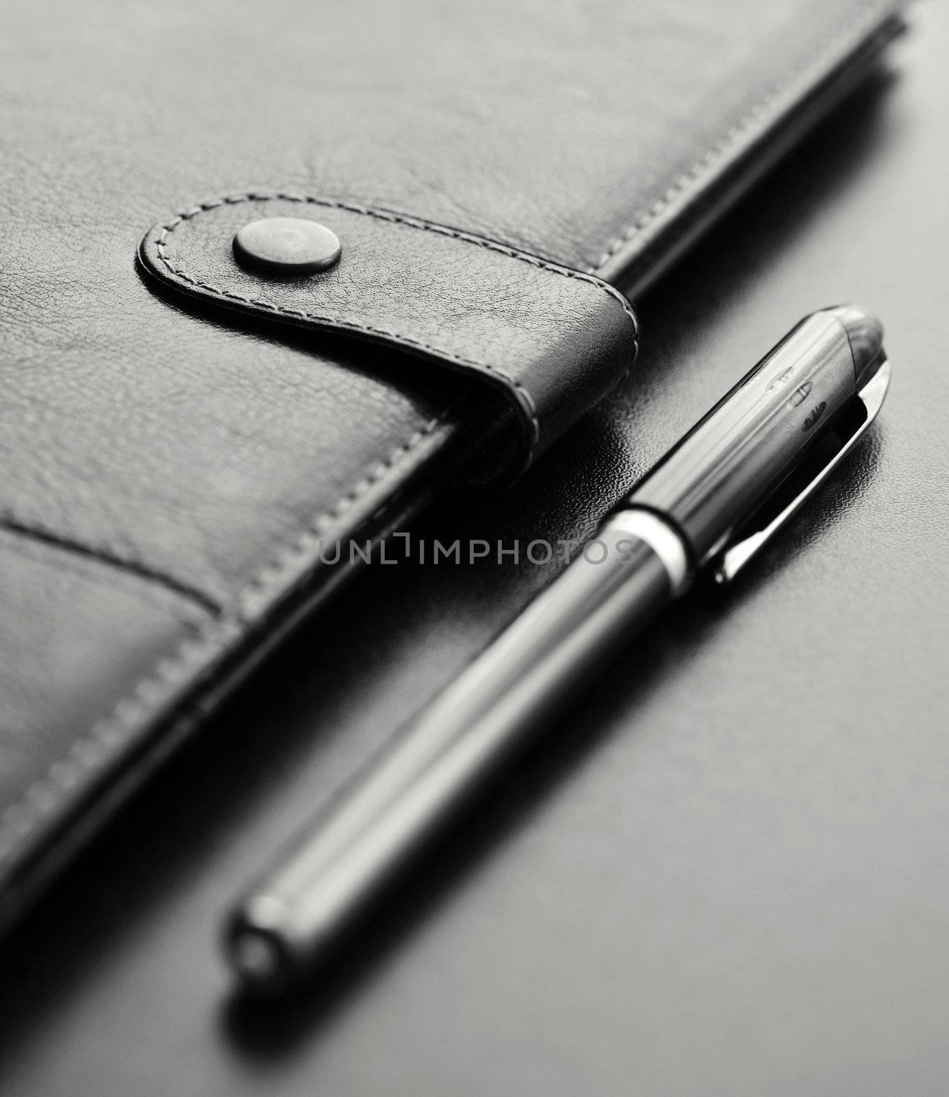 Close-up of a black personal agenda and with a pen with selective focus