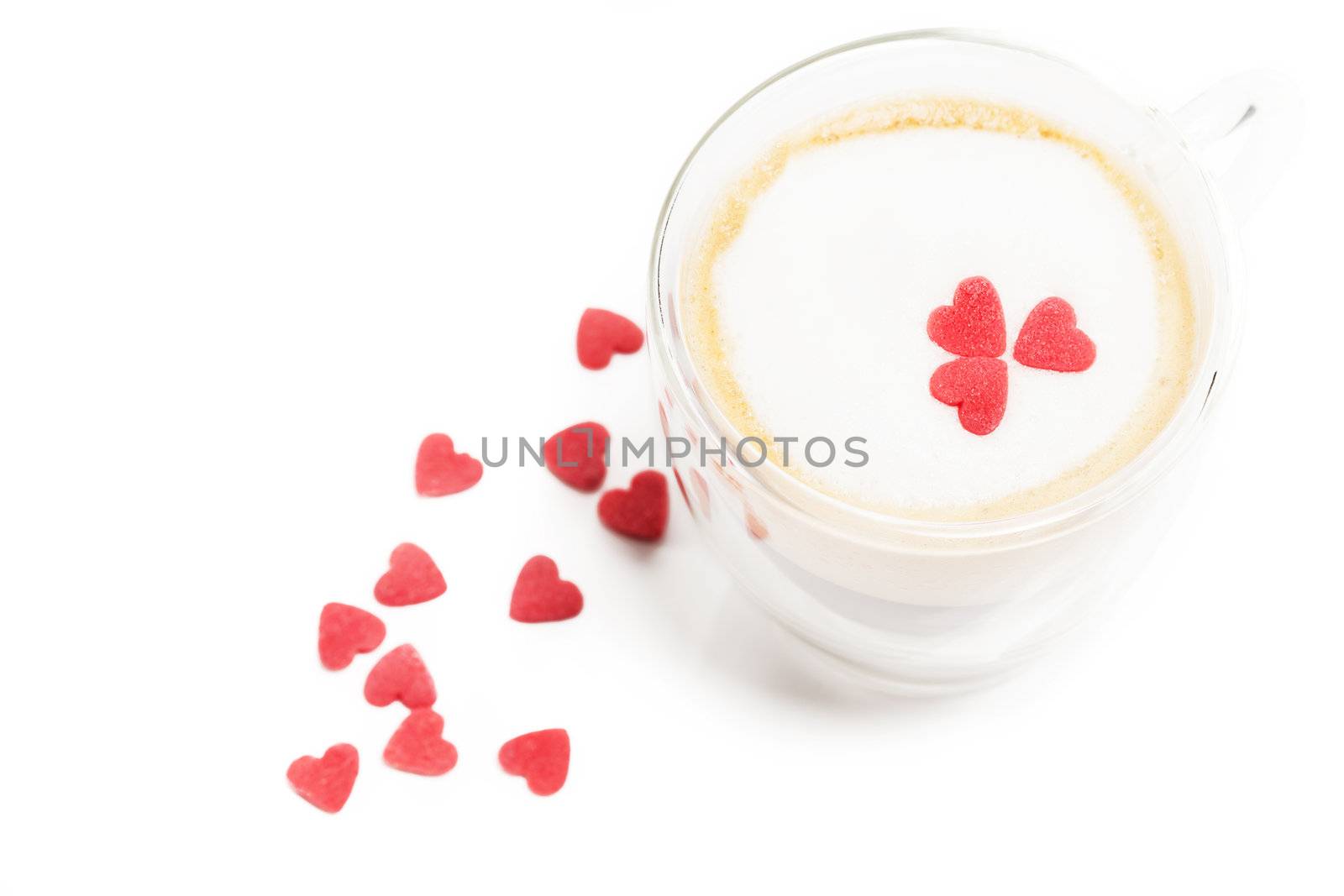 sugar hearts on and aside a espresso with milk foam on white background