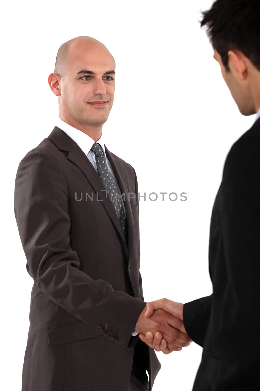 Two businessmen shaking hands by phovoir