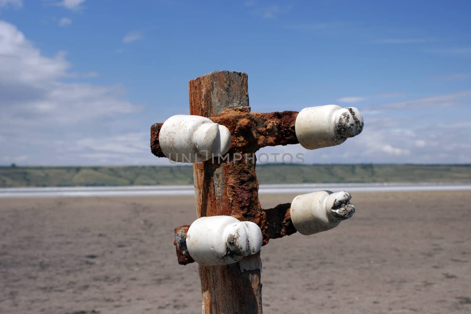 buried old wooden electricity pylons in the sand of Kuyal'nik Liman close up