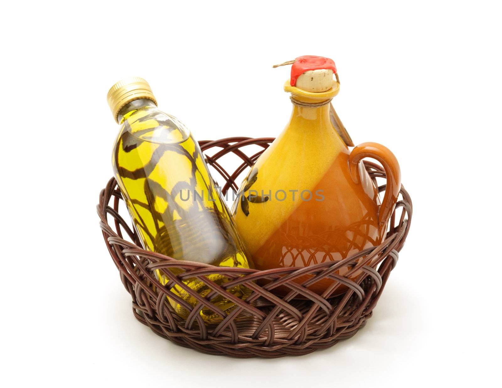 Bottle and jar of virgin olive oil in basket by Discovod