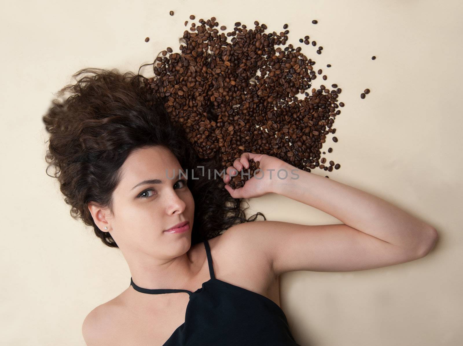 A woman with her hair is in coffee beans.