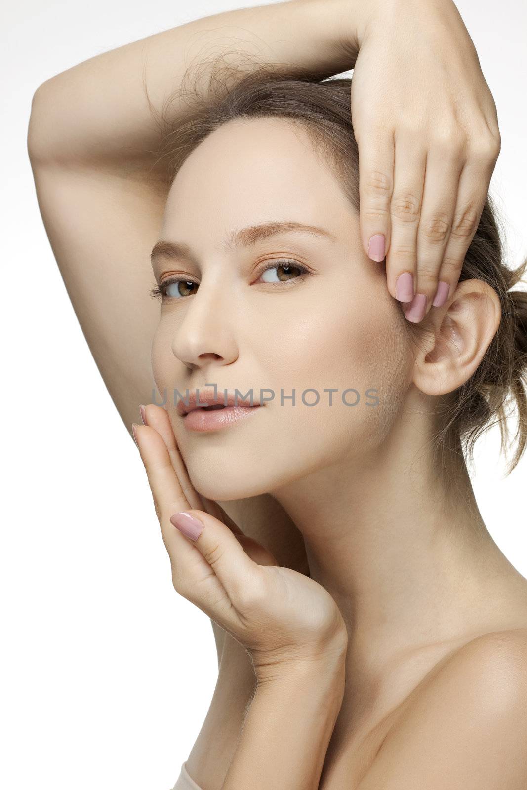 Close-up portrait of a beautiful young woman holding hands by her face 